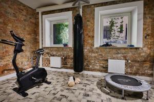 a room with a gym with a treadmill and a brick wall at Stabu Sēta Apartments in Rīga