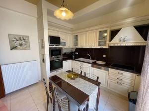 a kitchen with white cabinets and a table with chairs at Rita's Apartment in Heraklio Town