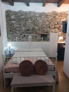 un letto bianco in una stanza con parete in pietra di Casa Varenne a Stropino