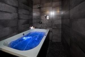 y baño con una gran bañera azul. en Stabu Sēta Apartments, en Riga