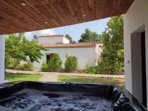 a large black tub in a yard with a house at Villa A CASA DI FICU proche d'Ajaccio avec piscine et jacuzzi in Peri