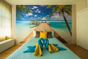 a bedroom with a mural of a beach and a pier at GM Apart in Varna City