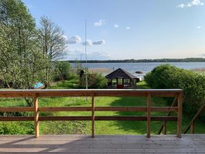 un banco de madera sentado en una terraza con vistas al lago en TaaliHomes Kuremaa ridaelamu järve kaldal - saun hinnas, en Kuremaa