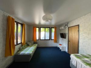 una camera con due letti e tende arancioni di Финский дом в Пицунде a Pizunda