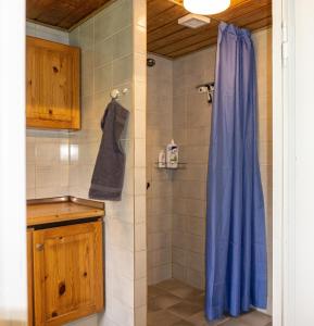 a bathroom with a shower with a blue shower curtain at Krog Feriehus in Billund