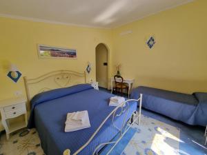 a bedroom with a blue bed and a couch at Il Ruscello in Maratea