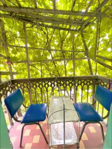 2 sillas y una mesa en un porche con árboles en Karson Guest House and Tours, en Ereván