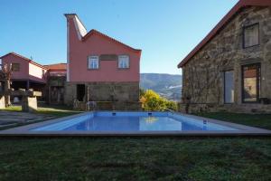 a swimming pool in the yard of a house at Quinta de Anterronde in Arouca