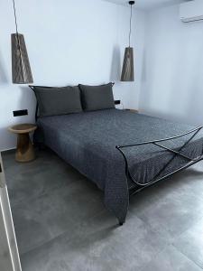 a bed in a white room with two lamps at Azul Houses Kythnos in Kithnos