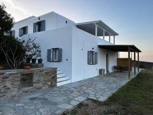 a white house with a stone walkway in front of it at Azul Houses Kythnos in Kithnos