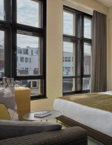 a hotel room with a bed and a couch and windows at W Amsterdam in Amsterdam