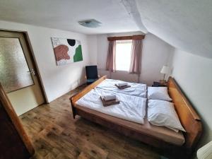 ein Schlafzimmer mit einem großen Bett und Holzboden in der Unterkunft Domek č. 3 in Pürstein
