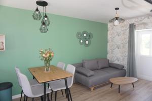 a living room with a table and a couch at Riva Home in Saint-Aignan
