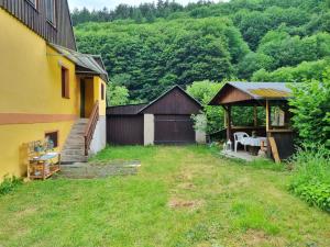 a backyard of a house with a table and a gazebo at Domek č. 3 in Perštejn