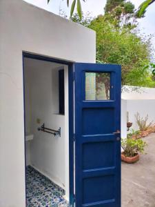 una puerta azul frente a una casa blanca en A' Riggiola, en Stromboli