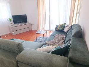 ein Wohnzimmer mit einem Sofa und einem TV in der Unterkunft Olive Tree in Podstrana