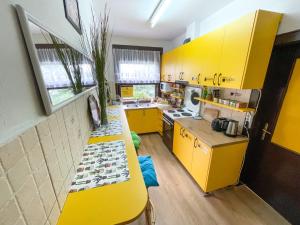 a yellow kitchen with yellow cabinets and a counter at Hi Skopje Hostel in Skopje