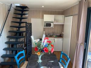 a kitchen and a table with a vase of flowers at Lou Mas Magnifique chalet avec très belle vue dominante 