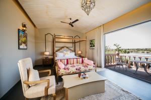 BeraにあるWelcomHeritage Cheetahgarh Resort & Spaのベッドルーム(ベッド1台付)、バルコニーが備わります。