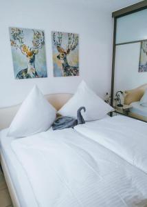 a white bed with a snake sitting on top of it at Ferienwohnung Bergjuwel in Fischen