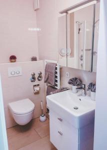 a white bathroom with a toilet and a sink at Ferienwohnung Bergjuwel in Fischen