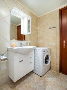 a bathroom with a washing machine and a sink at Kiriakos Holiday Home in Astris