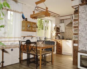 uma cozinha com uma mesa de madeira e cadeiras em Grafovi apartments em Narva