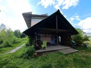 a small house with a deck in a field at Śródziemie Gondor in Leśno +10 photos
