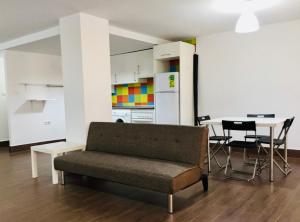 sala de estar con sofá y mesa con sillas en Apartamento familiar Torrelavega en Torrelavega