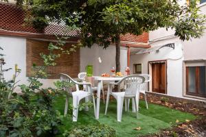 una mesa blanca y sillas en un jardín en Casa vacanze con giardino - Twiggy's House, en SantʼAntìoco