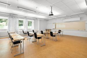 a classroom with tables and chairs and a chalkboard at Krongården Vandrarhem in Kristinehamn