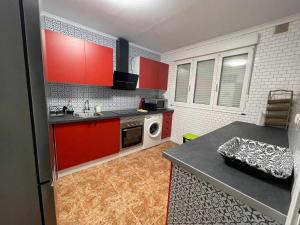 eine kleine Küche mit roten Schränken und einer Mikrowelle in der Unterkunft Casa Rural Mirador de Quintana in Priesca + 36 Fotos