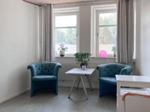 クリスティーネハムンにあるKrongården Vandrarhemの椅子2脚、テーブル、窓が備わる客室です。