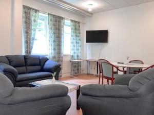 a living room with couches and a table and a tv at Krongården Vandrarhem in Kristinehamn