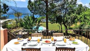 a table with plates of food on top of a balcony at Villa Casetta Bianca 2 chambres, Piscine et accès mer in Porto-Vecchio