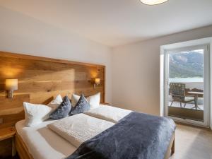 Schlafzimmer mit einem großen Bett mit einem Kopfteil aus Holz in der Unterkunft Appartements Am Achensee in Pertisau