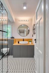 a bathroom with a sink and a mirror at Letni dom nad jeziorem Kaszuby Trójmiasto in Bieszkowice