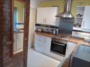 Rough Close的住宿－Very Peaceful Semi Detached Home Stoke on Trent，厨房配有白色橱柜和炉灶烤箱。