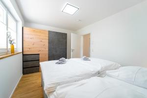 a white bedroom with a large bed and a window at Mit c in Feldberg