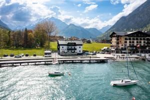 zwei Boote in einem Wasserkörper neben Gebäuden in der Unterkunft Appartements Am Achensee in Pertisau