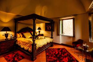 1 dormitorio con cama con dosel y alfombra roja en Castello Brancaccio en San Gregorio da Sassola