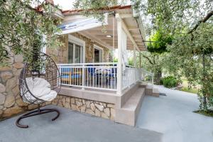 une terrasse couverte avec une balustrade blanche et une chaise dans l'établissement Kiriakos Holiday Home, à Astris