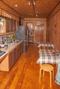 ソチにあるGuest House Landyshevayaのウッドフロアのキッチン(木製キャビネット、テーブル付)