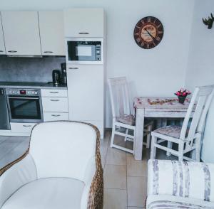 a kitchen with two chairs and a table with a clock at Ferienwohnung Bergjuwel in Fischen