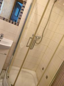 a shower with a glass door in a bathroom at Hostel 11 in Kozienice