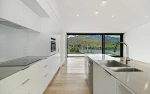 a white kitchen with a sink and a window at Highview terrance 3 bedrooms house queenstown in Queenstown