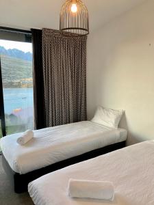 two beds in a room with a window at Highview terrance 3 bedrooms house queenstown in Queenstown