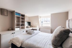 1 dormitorio con 1 cama blanca grande y escritorio en Stunning central Bath Apartment en Bath