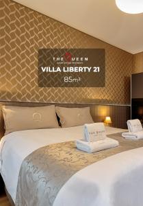 a hotel room with two beds and a sign that reads the queen villa library at The Queen Luxury Apartments - Villa Liberty in Luxembourg