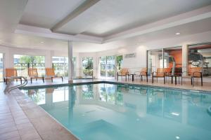 a swimming pool with chairs and tables in a building at Sonesta Select Chicago Elgin West Dundee in Elgin